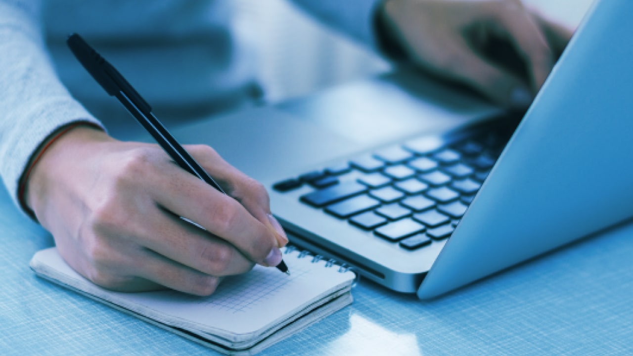 Man writing with laptop