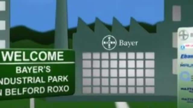Placa no parque industrial da Bayer em Belford Roxo com logotipos da empresa ao fundo.