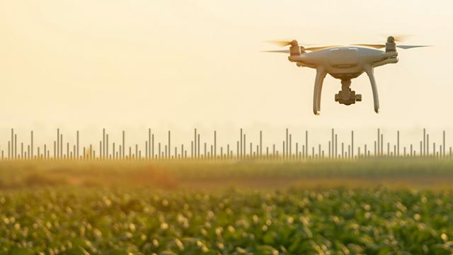 Um drone pairando sobre um campo verde com fundo desfocado e linhas indicando medições ou dados.