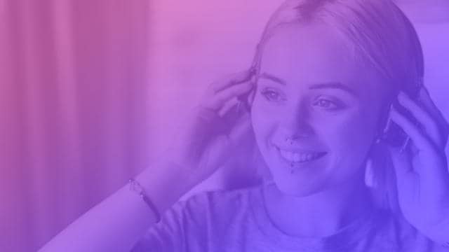 Pessoa com fones de ouvido, sorrindo, em uma imagem com tons de roxo.
